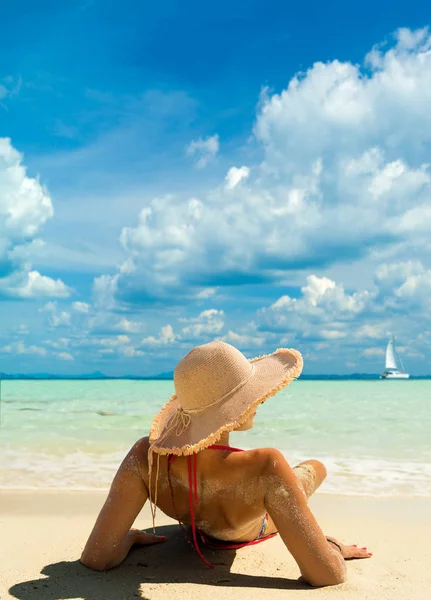 Загорающая на пляже женщина в бикини ложится тапком под канат — стоковое фото