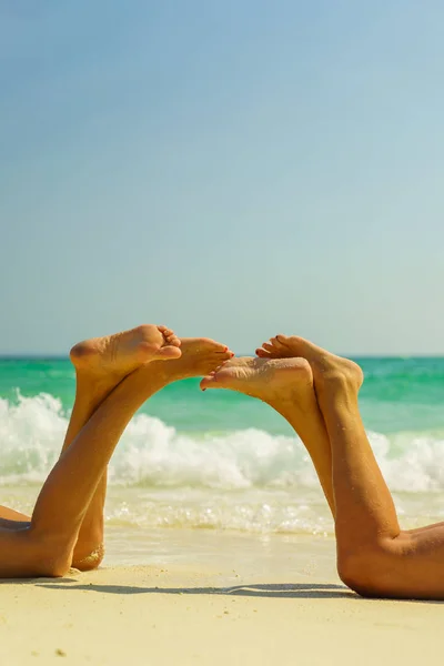 Dos hermosas piernas de las mujeres en la playa —  Fotos de Stock