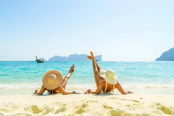 Two 2 young beautiful girls sunbathing on the tropical beach — Stock Photo, Image