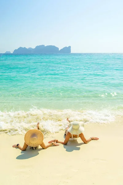 2位年轻漂亮的女孩在热带海滩上晒日光浴 — 图库照片