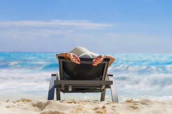 Leuke vrouw ontspannen op een zonnebank en kijk naar de zee kust. — Stockfoto