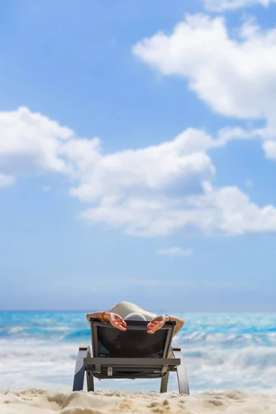 Ładna kobieta relaksujący na solarium i spojrzenie na brzegu morza. — Zdjęcie stockowe