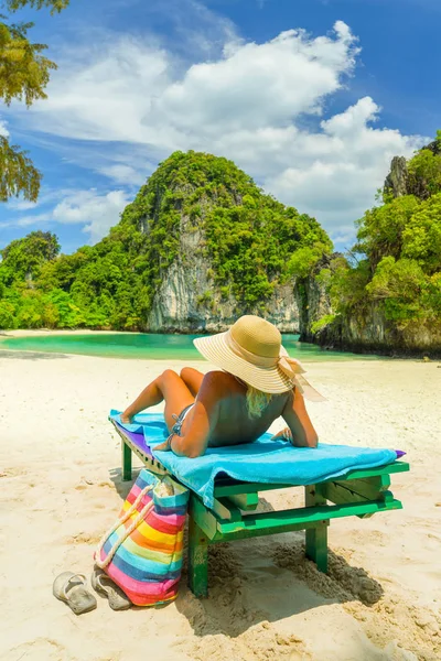 Kvinna sitter på en stol på stranden — Stockfoto