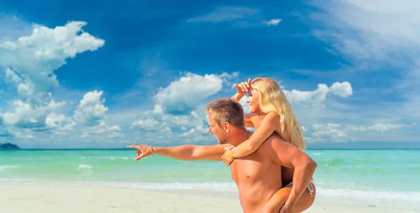 Hombre feliz en el amor dando paseo a cuestas a la mujer sonriente en el — Foto de Stock