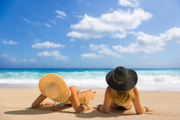 Две женщины в шляпе загорают в Лефкасе, Греция
 