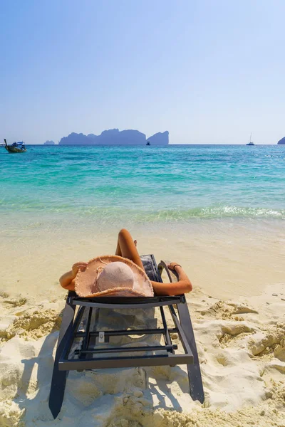 woman sunbathing lying down on a sunbed at the tropical beach summer travel holidays
