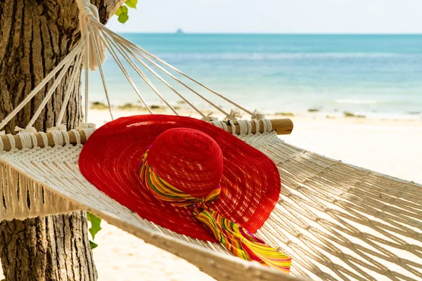 Red hat on a hammock at the beach summer holidays