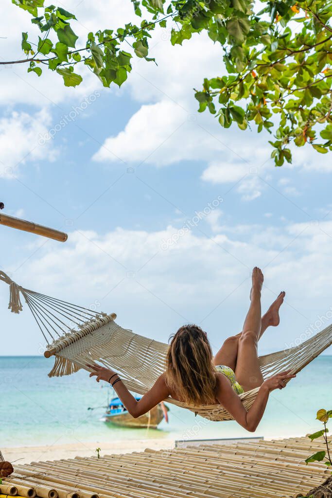 Woman relaxing at the beach on a hammock