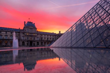 PARIS, FRANCE 19 Mart 2020: gündoğumunda Louvre Piramidi ile ünlü Louvre Müzesi manzarası. Louvre Müzesi dünyanın en büyük ve en çok ziyaret edilen müzelerinden biridir.