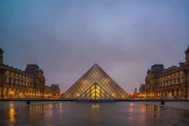 PARIS, FRANCE 19 Mart 2020: gündoğumunda Louvre Piramidi ile ünlü Louvre Müzesi manzarası. Louvre Müzesi dünyanın en büyük ve en çok ziyaret edilen müzelerinden biridir.