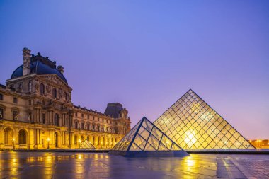 PARIS, FRANCE 19 Mart 2020: gündoğumunda Louvre Piramidi ile ünlü Louvre Müzesi manzarası. Louvre Müzesi dünyanın en büyük ve en çok ziyaret edilen müzelerinden biridir.