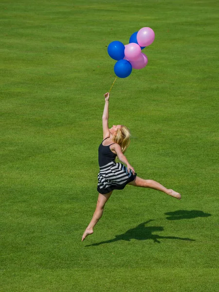 Vrouw Met Ballonnen Die Het Gras Springt — Stockfoto