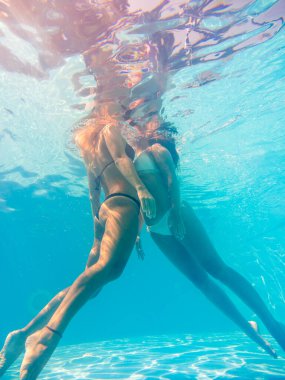 Arkadaşlar havuzda yüzüyor.