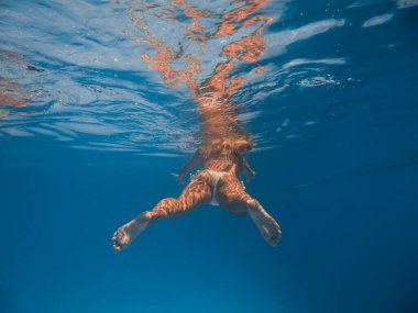 Kadın yüzme havuzunda suyun altında.
