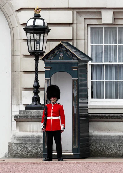 La Guardia de la Reina de guardia en el Palacio de Buckingham, la residencia oficial de la Reina de Inglaterra — Foto de Stock