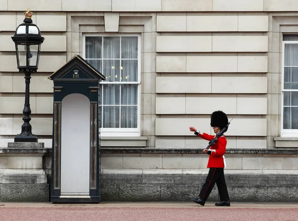 Královniny stráže ve službě na Buckinghamský palác, oficiální sídlo královny Anglie — Stock fotografie