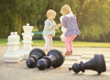 Dışarıda satranç figürleri olan bir çocuk.