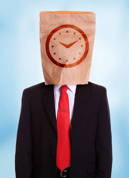 Hombre con una bolsa de papel en la esfera del reloj principal en él — Foto de Stock