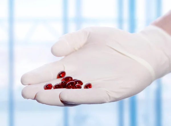 Pílulas vermelhas na mão — Fotografia de Stock