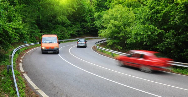 Cars on road in forest — Stock Photo, Image
