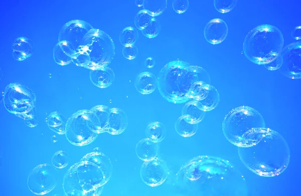 Burbujas de jabón con fondo azul — Foto de Stock