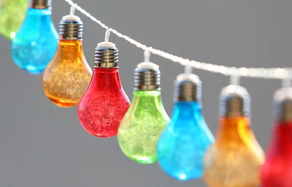 Colorful bulbs hang on string outdoor — Stock Photo, Image