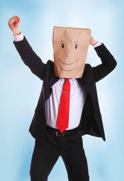 頭に笑顔で紙袋を持って幸せなビジネスマン — ストック写真