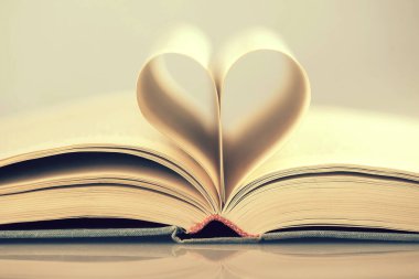 Kalp şeklinde kıvrılmış bir kitabın sayfaları 
