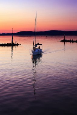 Gün batımında Balaton Gölü 'nde yelkenli.