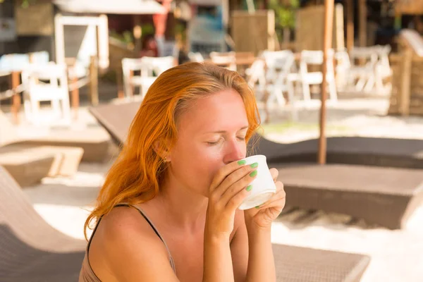 若い女性のビーチでコーヒーを飲んで — ストック写真