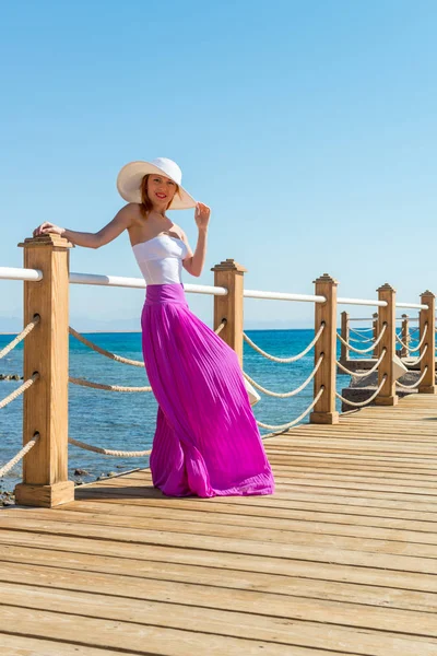 Beautiful woman wearing hat and pink skirt — Stock Photo, Image