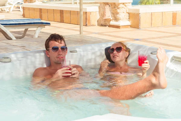 Jeune couple relaxant dans la piscine jacuzzi — Photo