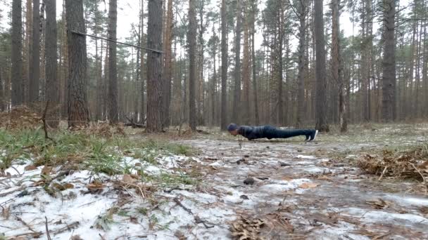 Young Athletic Man Performs Pushups in forest — Stock Video