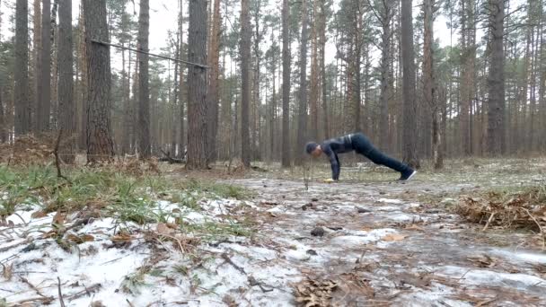 Young Athletic Man Performs Pushups in forest — Stock Video