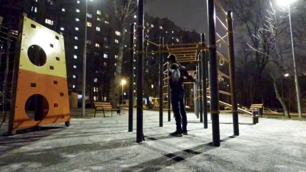 Man working out on sports ground at night time — Stock Video