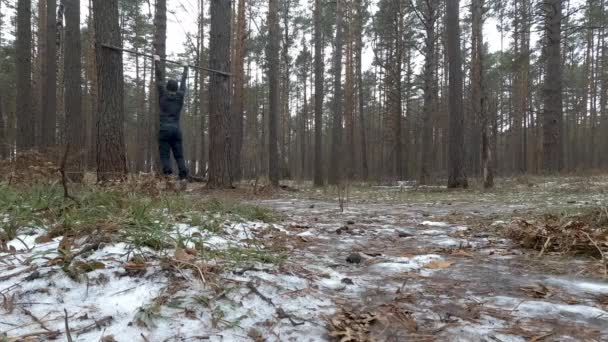 Homem Atlético Jovem Executa Pullups na floresta — Vídeo de Stock