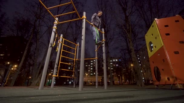 Hombre haciendo ejercicio en el campo de deportes por la noche — Vídeos de Stock