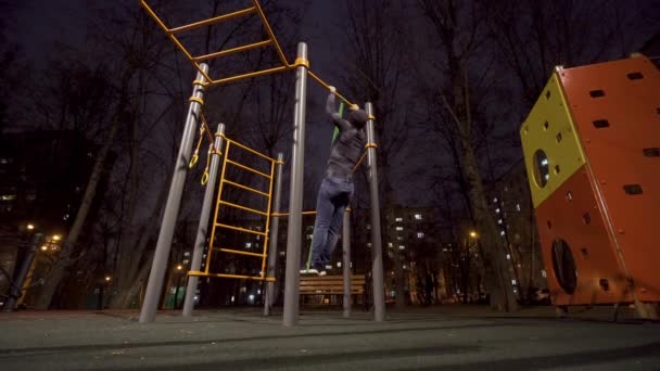 남자는 밤에 운동 경기장에서 운동을 하고 있다 — 비디오