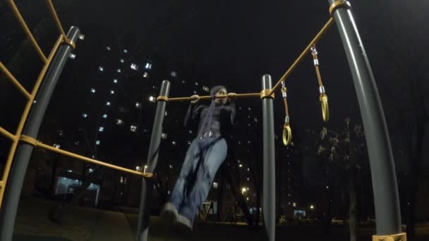 Hombre haciendo ejercicio en el campo de deportes por la noche — Vídeo de stock