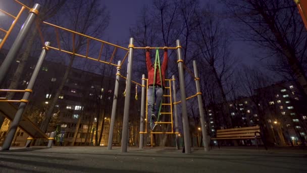 Hombre haciendo ejercicio en el campo de deportes por la noche — Vídeos de Stock