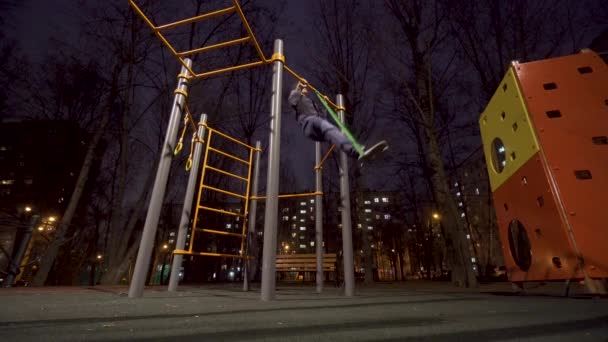 Человек тренируется на спортивной площадке в ночное время — стоковое видео