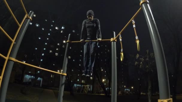 Man working out on sports ground at night time — Stock Video