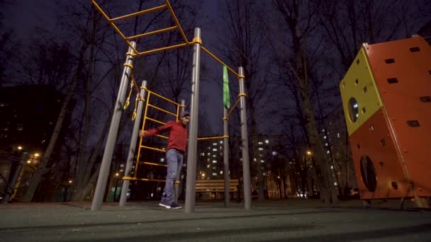 남자는 밤에 운동 경기장에서 운동을 하고 있다 — 비디오