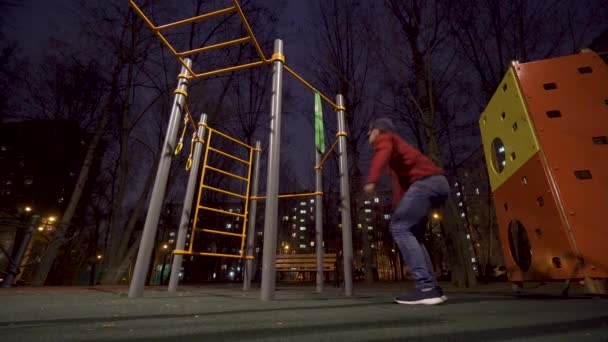 Muž cvičit na sportovním hřišti v noci — Stock video