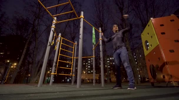 Man working out on sports ground at night time — Stock Video