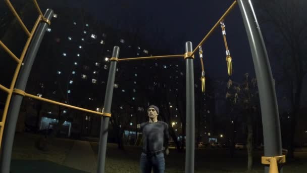 Hombre haciendo ejercicio en el campo de deportes por la noche — Vídeo de stock