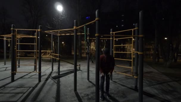 Тімелапсе Чоловік працює на спортивному майданчику в нічний час — стокове відео