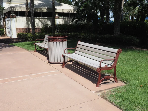 Two garden benches by a sidewalk — Stock Photo, Image