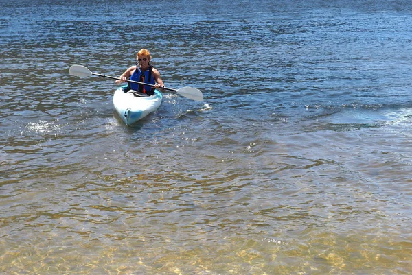 Teenage boy in a kayak on a lake in summer — Stock Photo, Image