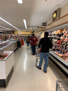 Nasıra, Pennsylvania / ABD - 18 Nisan 2020: müşteriler COVID19 sırasında bir markette çıkış yapmak için uzun bir kuyrukta bekliyorlar. Müşteriler 1.80 'lik sosyal mesafeler kuralına uyuyor ve yüz maskesi takıyorlar..